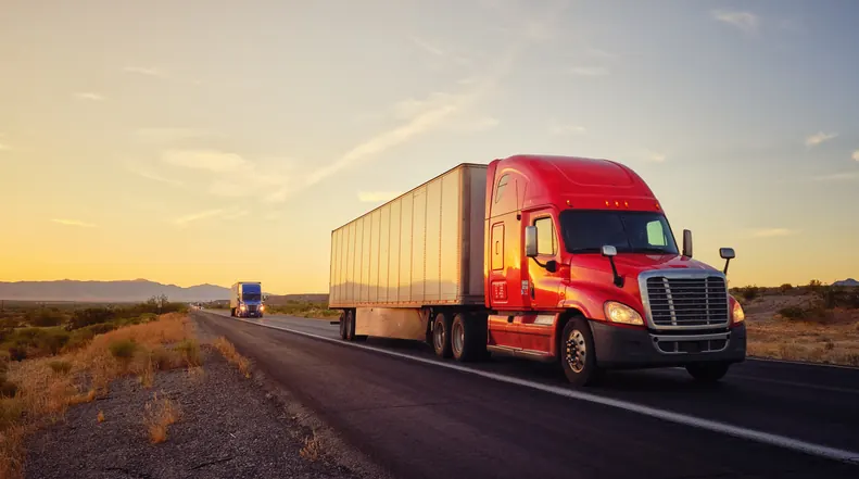 Two Freightliner trucks traveling Oklahoma highway at sunset — Bledsoe Truck & Trailer Repair offers scheduled fleet maintenance programs for OKC owner-operators and small fleets.