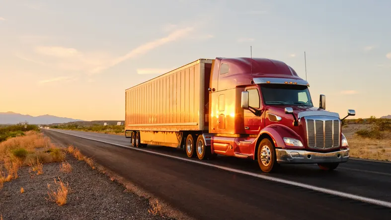 Red Peterbilt semi truck on Oklahoma highway at sunset — Bledsoe Truck & Trailer Repair serves the I-44 corridor with heavy-duty truck repair in the Oklahoma City metro.